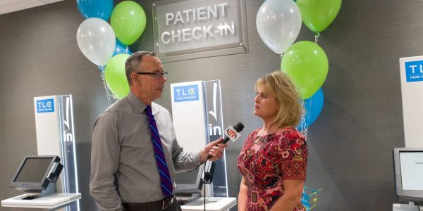 Sharma Gaughan, Director of Patient Accounts in front of our new check-in kiosk